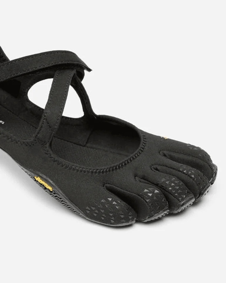 A close-up of the Vibram V-Soul (Women’s), a black minimalist shoe featuring individual toe pockets and a textured sole, designed to mimic the shape of a bare foot—perfect for pilates and functional fitness enthusiasts seeking natural movement.