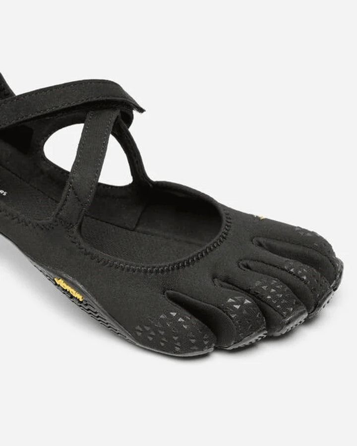 A close-up of the Vibram V-Soul (Women’s), a black minimalist shoe featuring individual toe pockets and a textured sole, designed to mimic the shape of a bare foot—perfect for pilates and functional fitness enthusiasts seeking natural movement.