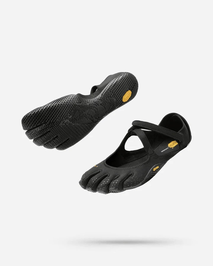 Two pairs of Vibram V-Soul (Women’s) black minimalist barefoot shoes, featuring separate toe sections, flexible soles, and a top strap—perfect for yoga or pilates—are shown floating against a white background.