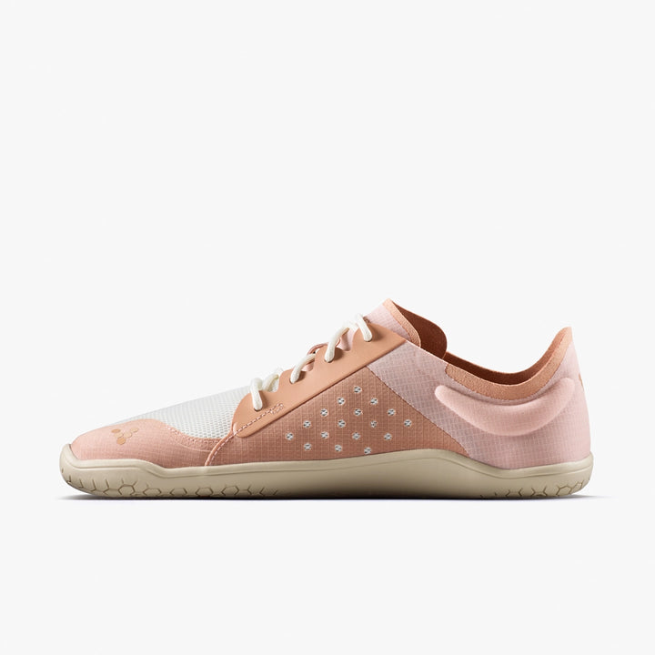 The VIVOBAREFOOT Primus Lite IV (Women's) is a minimalist barefoot trainer in light pink and beige, featuring a white mesh upper, beige sole, white laces, low profile for natural movement, subtle branding, and textured grip pattern.