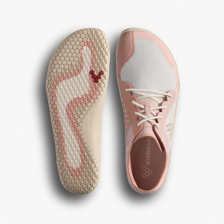 The VIVOBAREFOOT Primus Lite IV (Women's) barefoot trainers in pink and white are shown from the side and sole; the hexagonal-patterned sole has a reddish stain, with laces and the Vivobarefoot logo visible on the insole.
