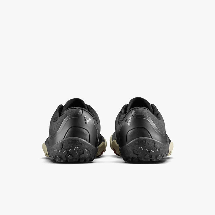 A pair of VIVOBAREFOOT Primus Trail III All Weather FG men's sneakers in black, displayed from the back to highlight their textured soles and small reflective logos on each heel, set against a plain white background.
