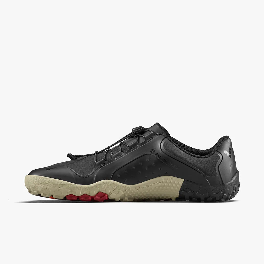 The VIVOBAREFOOT Primus Trail III All Weather FG (Men's) is a black, water-resistant trail sneaker with a minimalist design, featuring a beige textured sole, red accents, toggle lacing, and a low profile—shown from the side on a white background.