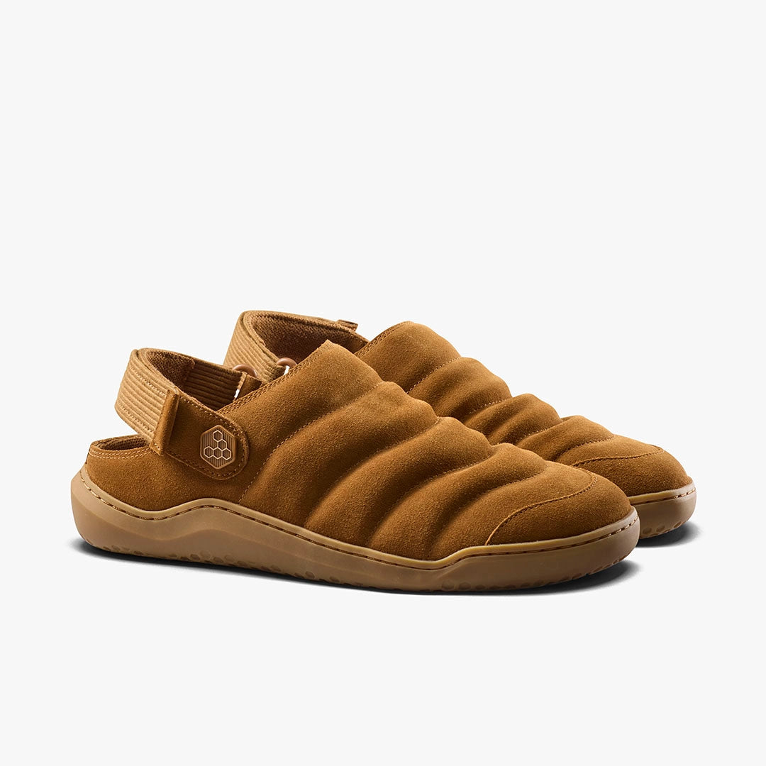 The Gobi Wavey Mule (Men’s) features quilted brown leather, padded uppers, a round toe, adjustable back strap, and rubber soles for casual comfort.