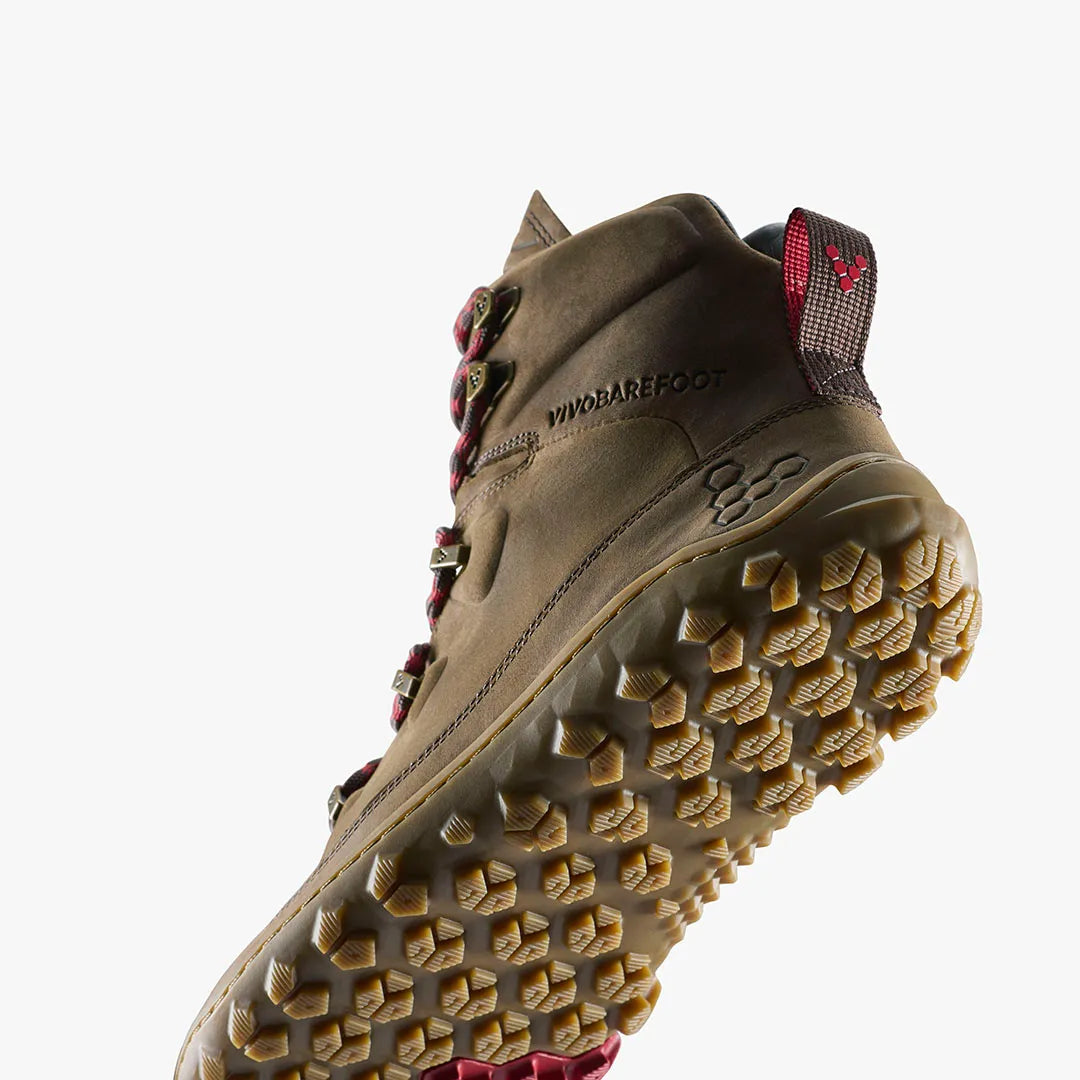 The VIVOBAREFOOT Tracker Leather AT II (Women's) is a tan barefoot hiking boot with red laces and a rugged sole, shown from a low angle on a white background with the brand visible on the side.