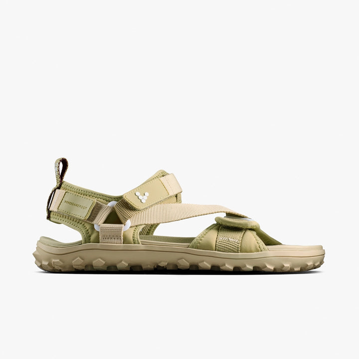 The VIVOBAREFOOT Tracker Ora Sandal (Men's) is shown in profile against a white background, featuring a khaki and beige neoprene upper, open toe, adjustable straps, rugged sole, and subtle side branding.