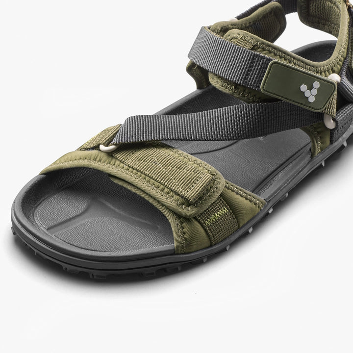 Close-up of the VIVOBAREFOOT Tracker Ora Sandal (Women's) in olive green and black, featuring adjustable gray straps, a neoprene upper, velcro closures, and a textured footbed on a white background.