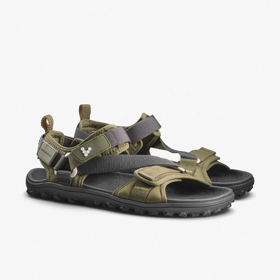 The VIVOBAREFOOT Tracker Ora Sandal (Women's) features olive green and black adjustable straps, a neoprene upper, rugged traction sole, and side logo details, shown on a plain white background.
