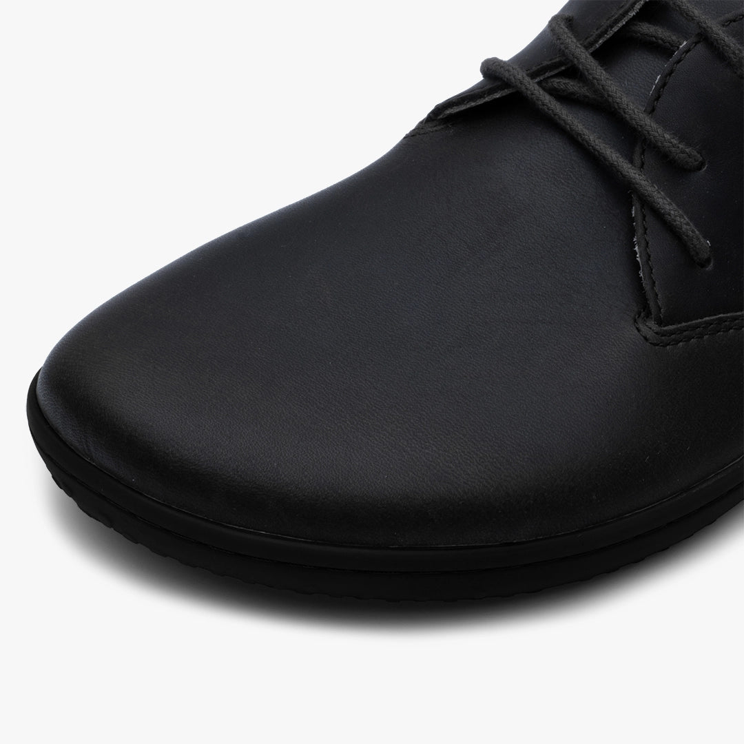 Close-up of the Ra IV (Men's) by VIVOBAREFOOT, featuring the barefoot Oxford’s smooth Wild Hide leather, rounded toe, and black laces set against a plain white background.