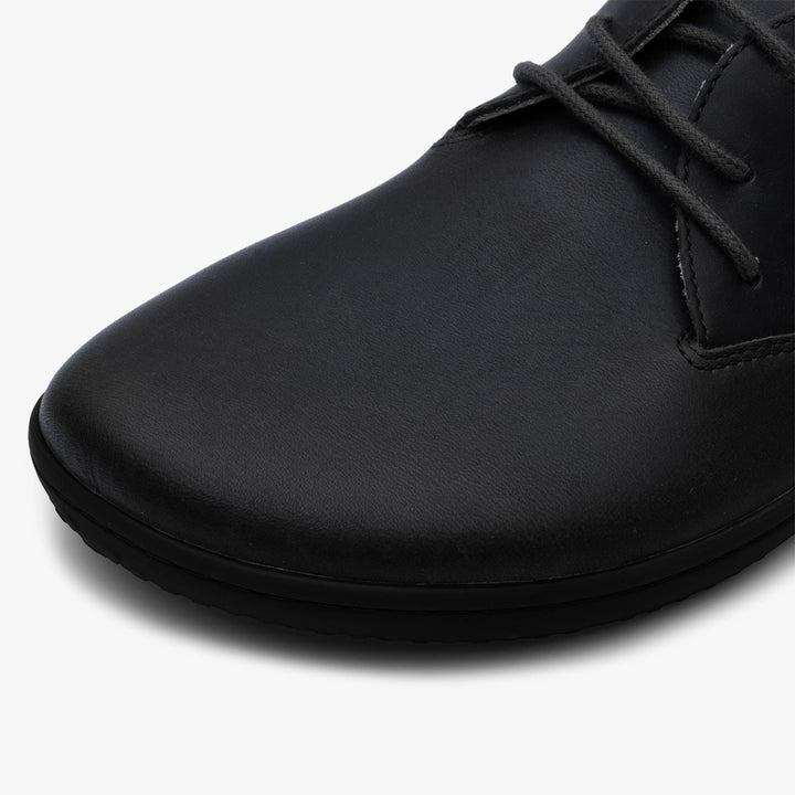 Close-up of the Ra IV (Men's) by VIVOBAREFOOT, featuring the barefoot Oxford’s smooth Wild Hide leather, rounded toe, and black laces set against a plain white background.