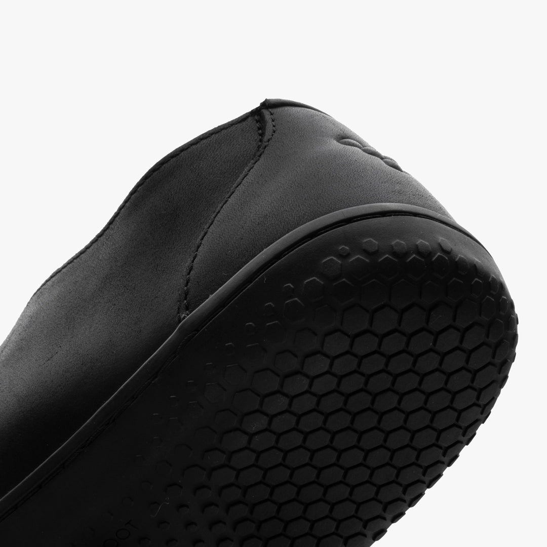 Close-up of the Ra IV (Men's) by VIVOBAREFOOT: shows the black heel and flexible Gobi outsole with a textured hexagonal tread, set against a plain white background.