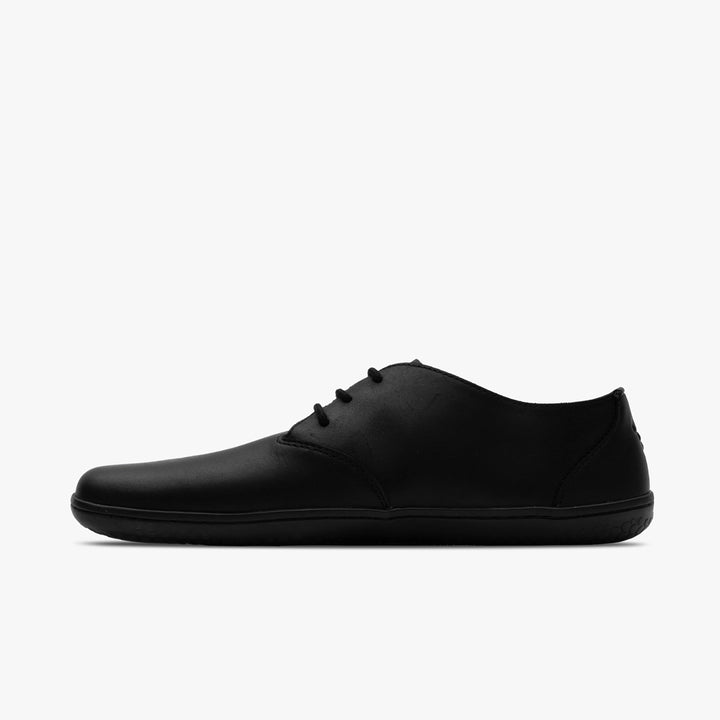 The VIVOBAREFOOT Ra IV (Men's) is a minimalist black barefoot Oxford with a low-profile flat sole and simple Wild Hide leather design, shown in side view against a plain white background.