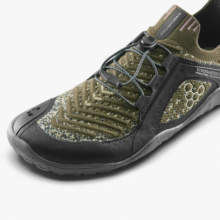 An olive green VIVOBAREFOOT Primus Trail Knit FG Grounding (Men’s) shoe with a black firm ground sole and toggle lacing system.