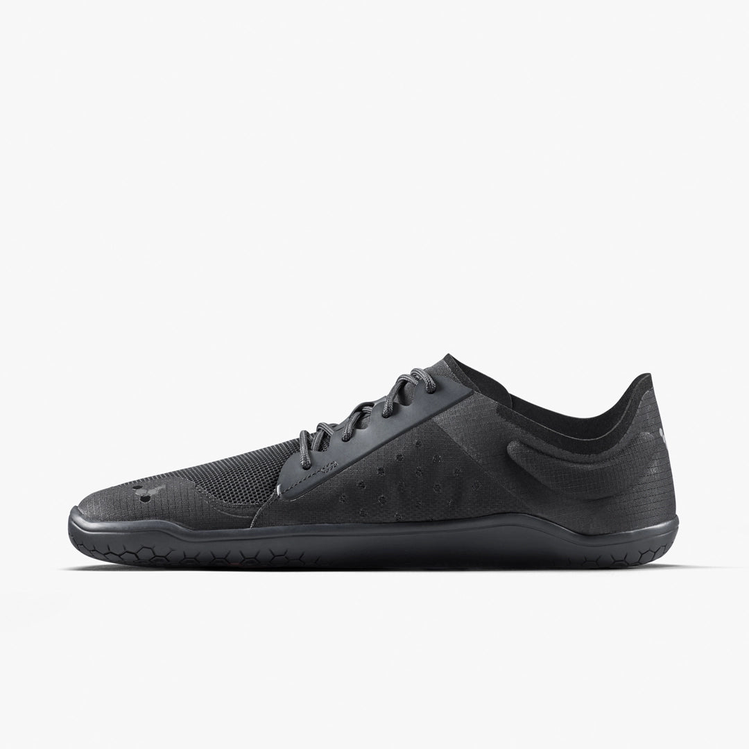 The VIVOBAREFOOT Primus Lite IV (Men’s) is a minimalist black performance trainer with a low profile, mesh upper, and thin rubber sole for barefoot running. Side view displayed on a plain white background.