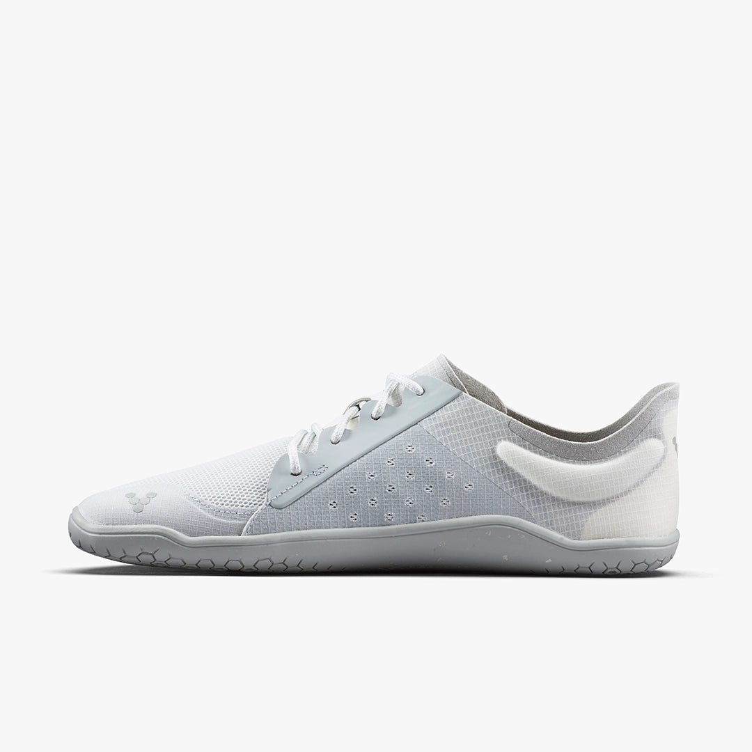 The VIVOBAREFOOT Primus Lite IV (Men's) is a minimalist white and light gray athletic shoe with a mesh upper, thin sole, and lace-up closure made from recycled materials, shown in side profile on a plain white background.