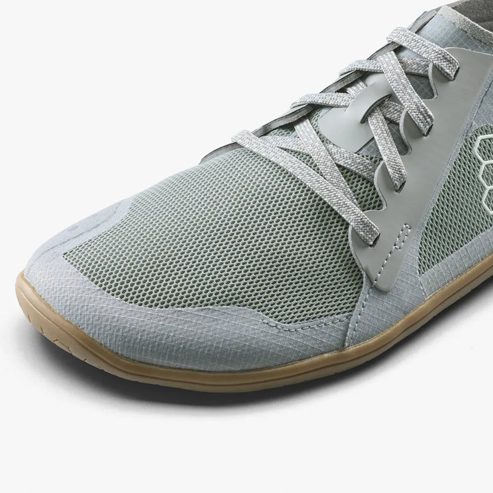 A light gray mesh vegan Primus Lite IV (Women’s) running shoe with a thin gum sole.
