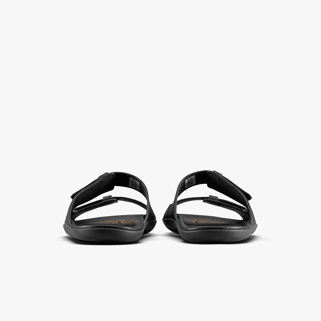 A pair of VIVOBAREFOOT Sensus Yin Slide (Men's) sandals in black are shown from the back with adjustable straps and a flat Earthfoam sole, set against a plain white background.