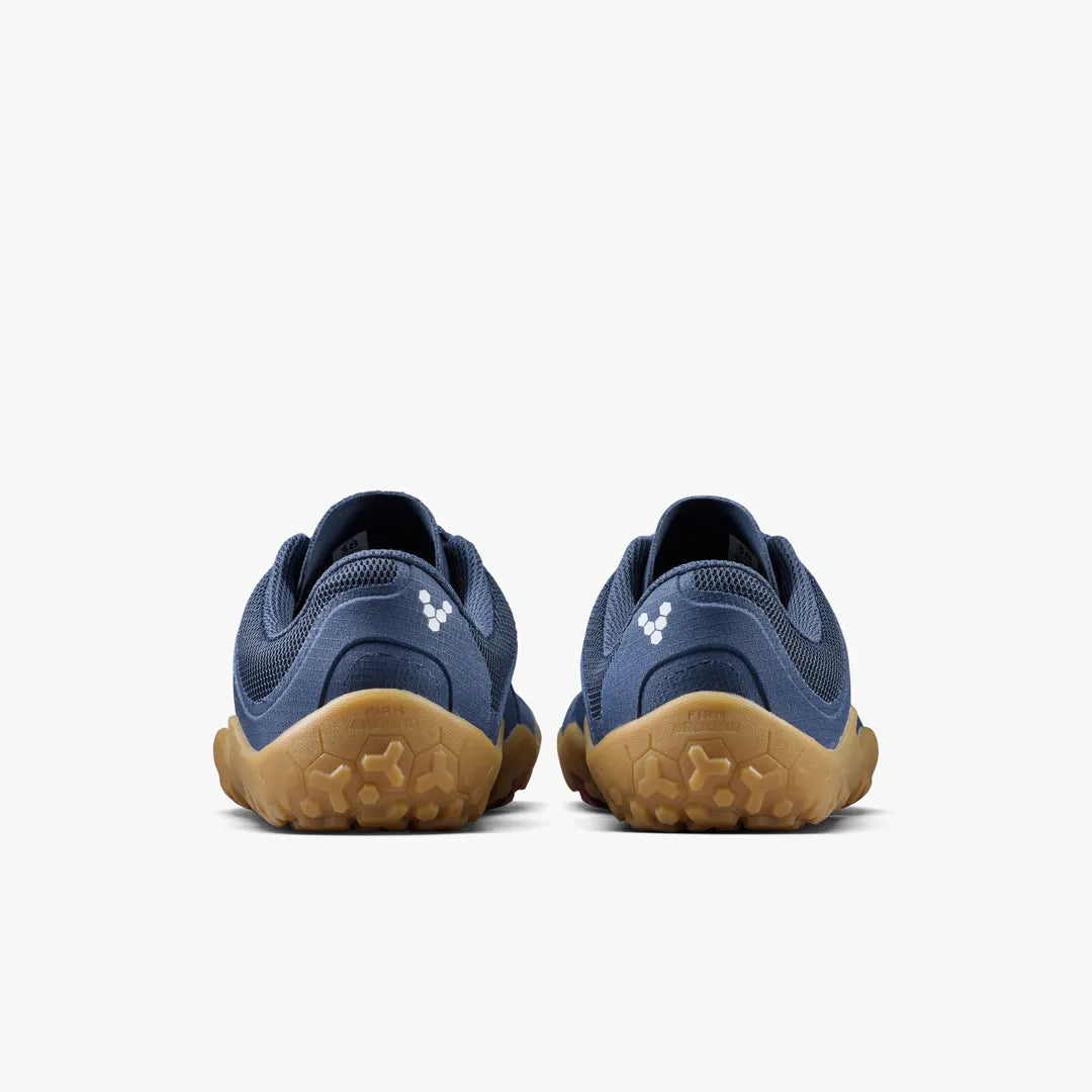 The VIVOBAREFOOT Primus Trail FG 3.5 (Men’s) trail-running trainers are featured from the back, showcasing their blue uppers with tan soles against a plain white background. Each shoe has a small white logo near the heel.