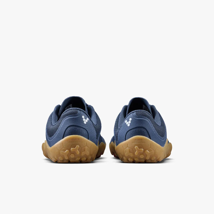 The VIVOBAREFOOT Primus Trail FG 3.5 (Men’s) trail-running trainers are featured from the back, showcasing their blue uppers with tan soles against a plain white background. Each shoe has a small white logo near the heel.