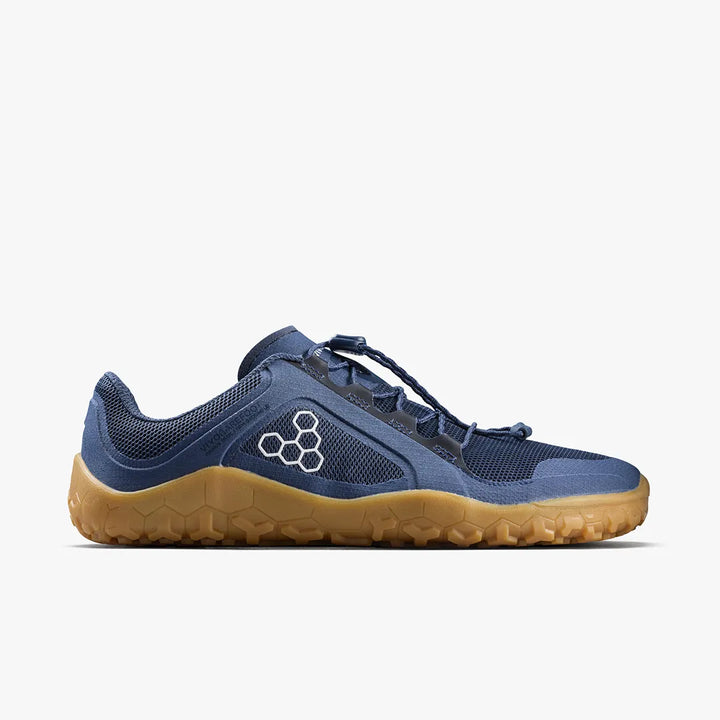 A left-side view of the VIVOBAREFOOT Primus Trail FG 3.5 (Men’s), featuring a blue breathable mesh upper, tan rubber sole, and a hexagonal logo on the side, set against a white background.