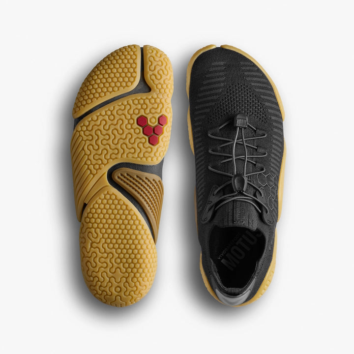 Two black VIVOBAREFOOT Motus Flex Natural (Men's) shoes with yellow, textured natural rubber outsoles featuring a unique pattern and red hexagon logo; one shoe is shown top-down, the other displays the sole.