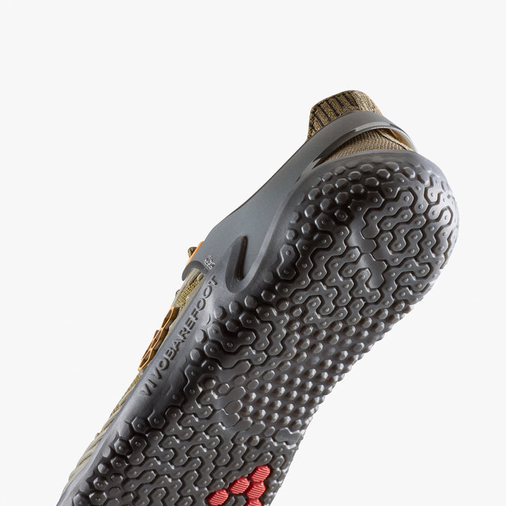Close-up of the VIVOBAREFOOT Motus Strength II (Men's) sole, featuring a textured black rubber tread with red hexagons at the front. The olive green upper adds style, making it ideal for high-impact workouts.