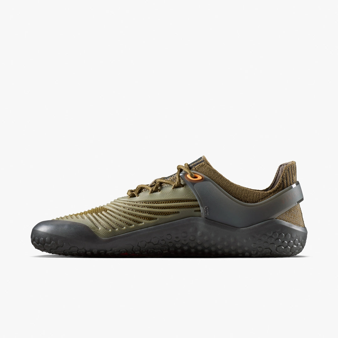 A side view of the VIVOBAREFOOT Motus Strength II (Men's) in olive green and brown features a textured sole, ribbed upper, mesh details, and orange lace eyelets—ideal for high-impact workouts—displayed on a plain white background.