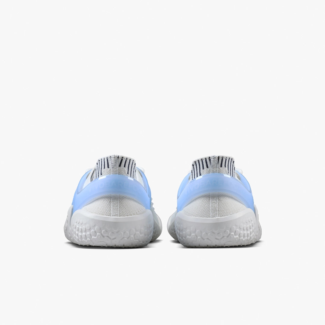 A pair of VIVOBAREFOOT Motus Strength II (Men's) barefoot trainers seen from the back, featuring light blue uppers, white textured soles, and black-and-white striped heel pull-tabs against a plain white background.