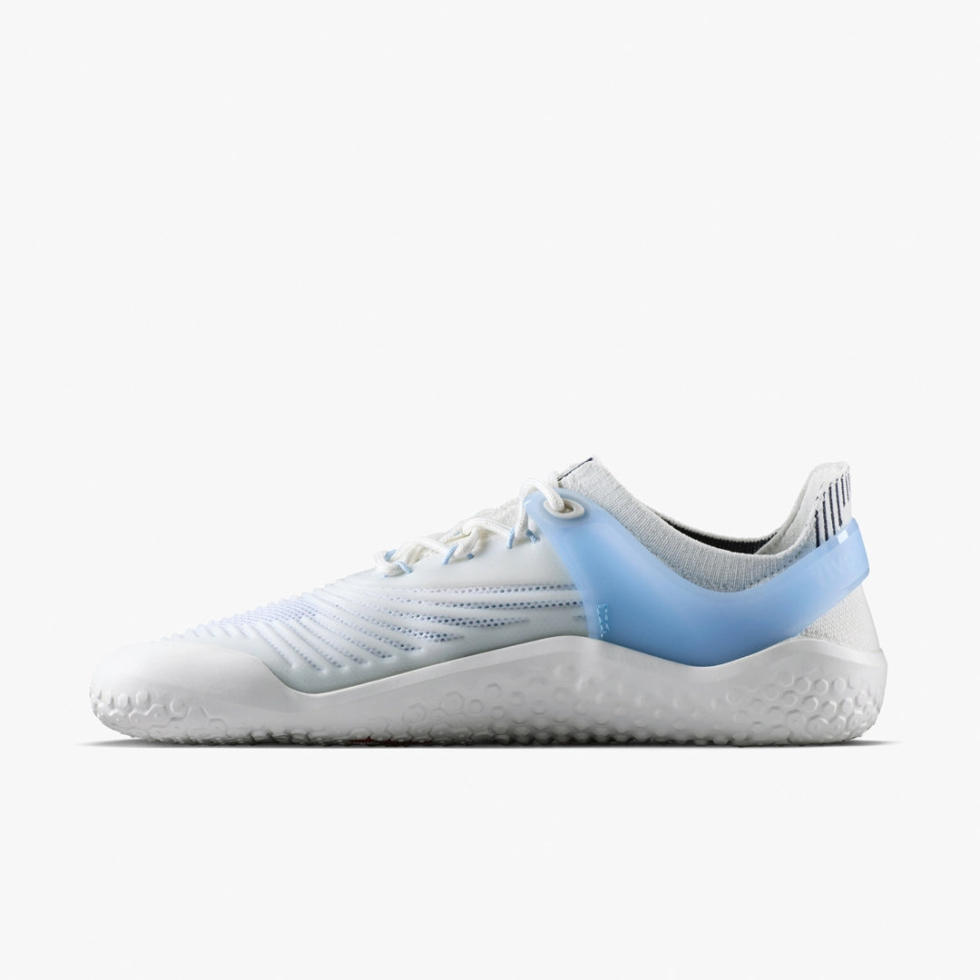 The VIVOBAREFOOT Motus Strength II (Women's) is a white barefoot CrossFit trainer with light blue accents, a textured sole, and white laces, shown on a plain white background.