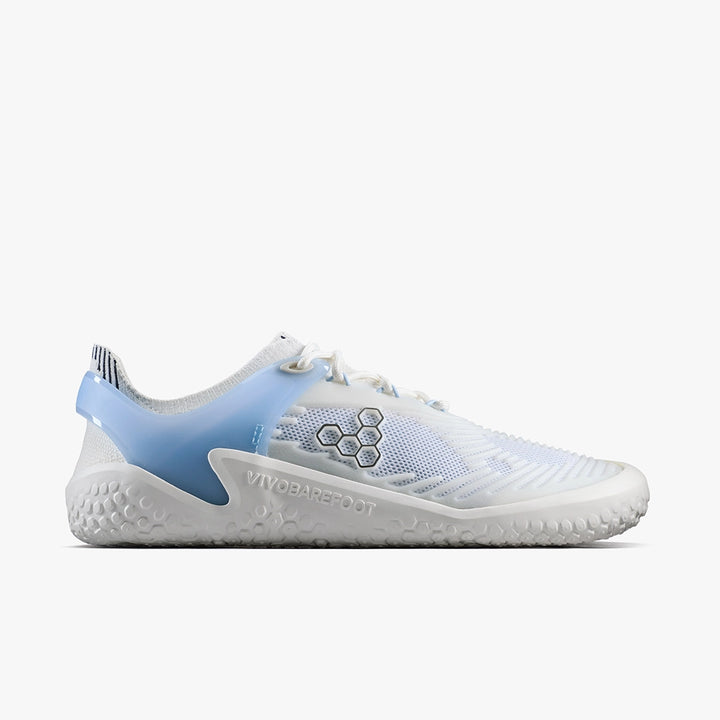 The Motus Strength II (Men’s) by VIVOBAREFOOT features a white and light blue mesh upper, textured sole, hexagonal side logo, and embossed branding near the heel—ideal for high-impact workouts or CrossFit.