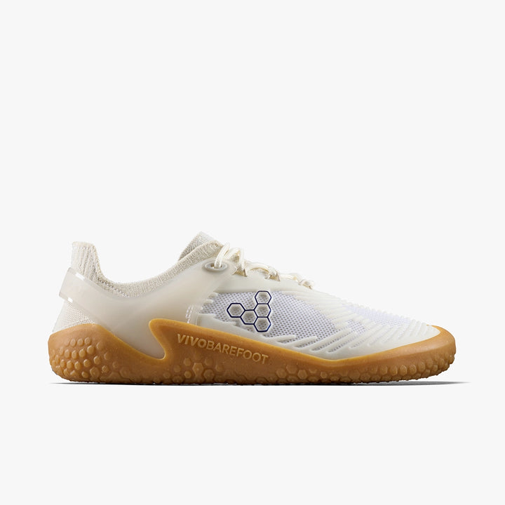 The VIVOBAREFOOT Motus Strength II (Women's) is a white and beige minimalist barefoot trainer with a mesh upper, perforated for breathability, textured gum sole, white laces, and side logo—perfect for functional fitness.