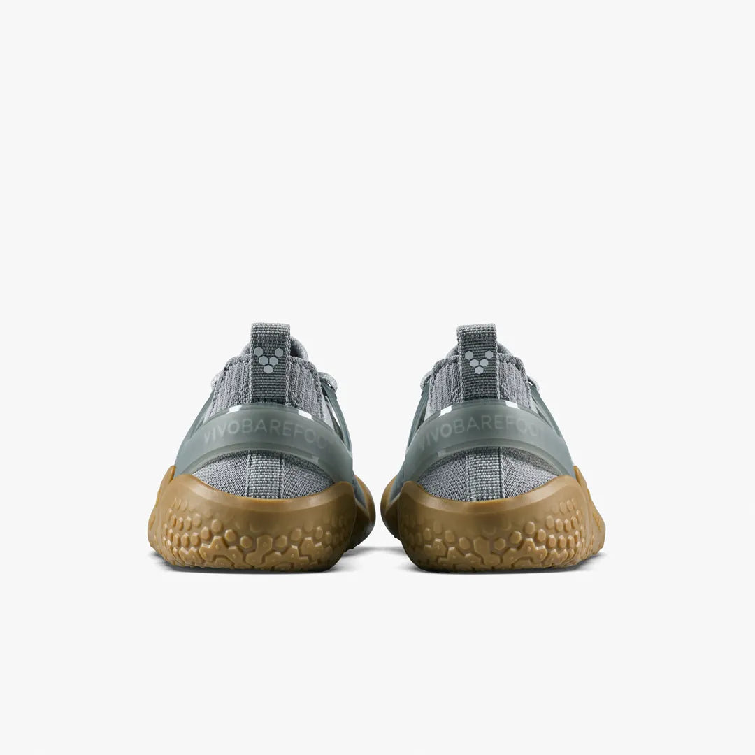 The back view of a pair of gray VIVOBAREFOOT Motus Strength II (Women’s) trainers with textured gum soles and a supportive upper.