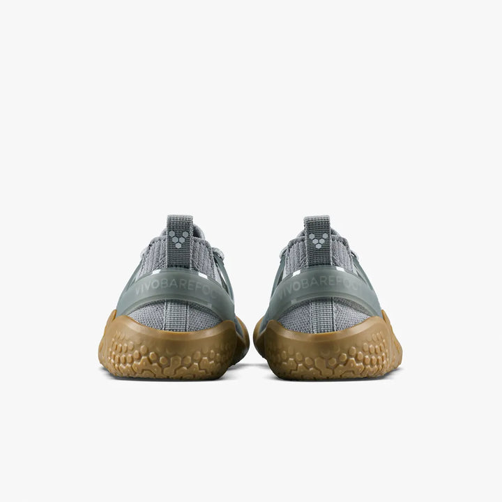The back view of a pair of gray VIVOBAREFOOT Motus Strength II (Women’s) trainers with textured gum soles and a supportive upper.