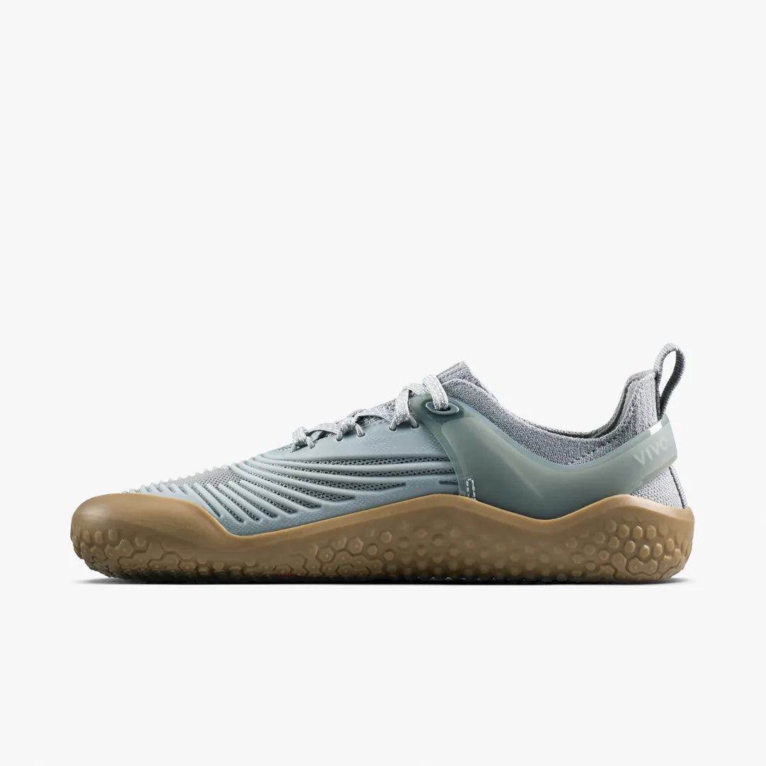 A grey Vivobarefoot Motus Strength II (Women’s) barefoot strength trainer with a supportive upper and a gum-colored textured sole.