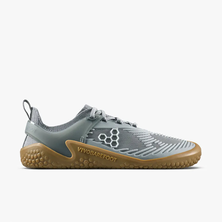 A grey VIVOBAREFOOT Motus Strength II (Women’s) barefoot strength trainer with a gum-colored textured sole and a supportive upper.