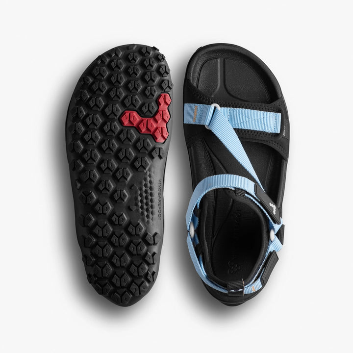 A pair of black VIVOBAREFOOT Tracker Ora Sandals (Men's) featuring rugged All Terrain Outsoles, light blue adjustable straps, a red logo on the sole of one sandal, and a barefoot experience footbed visible from the top view.