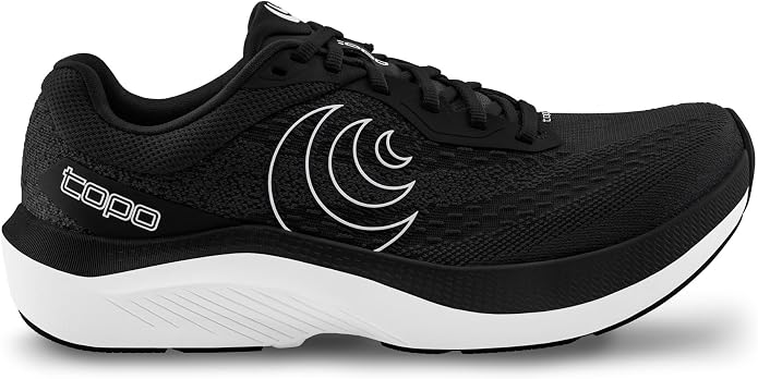 The TOPO Magnifly 6 (Women’s) is a black running shoe featuring a breathable mesh upper, a white sole, distinctive white curved side detailing, and the word “topo” printed in white near the heel. Renowned for its zero-drop platform and plush cushioning, it delivers exceptional comfort as one of the most popular cushioned athletic options for women.
