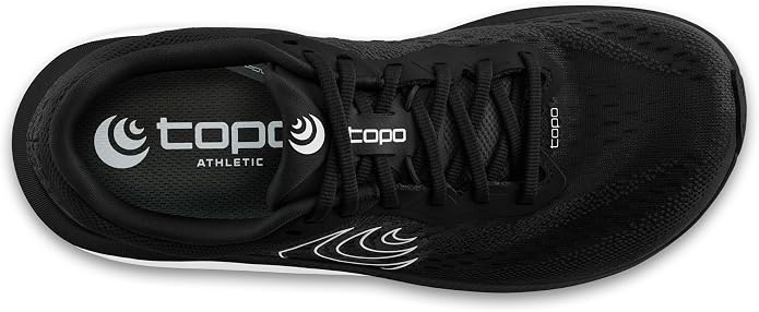 Top view of the TOPO Magnifly 6 (Women’s), a black cushioned running shoe featuring black laces, a white TOPO logo on the insole, and a subtle white accent near the laces—ideal for runners looking for zero drop footwear.