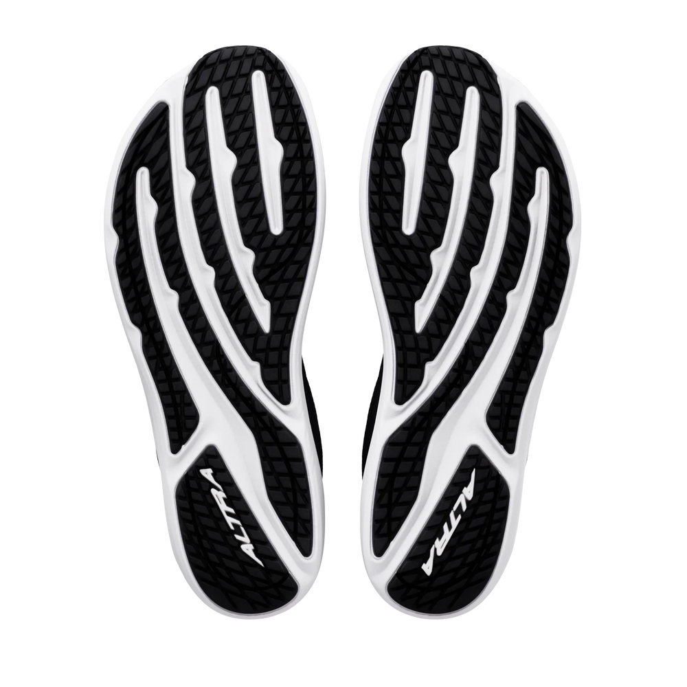 The black and white soles of the ALTRA Escalante 5 (Men’s) shoes are displayed from the bottom against a white background, showcasing textured tread patterns and the ALTRA logo on each sole. Designed with zero drop construction and ALTRA’s signature FootShape Fit for natural comfort, these shoes are a standout in the Escalante 5 collection.