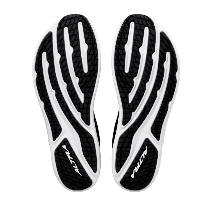 The black and white soles of the ALTRA Escalante 5 (Men’s) shoes are displayed from the bottom against a white background, showcasing textured tread patterns and the ALTRA logo on each sole. Designed with zero drop construction and ALTRA’s signature FootShape Fit for natural comfort, these shoes are a standout in the Escalante 5 collection.