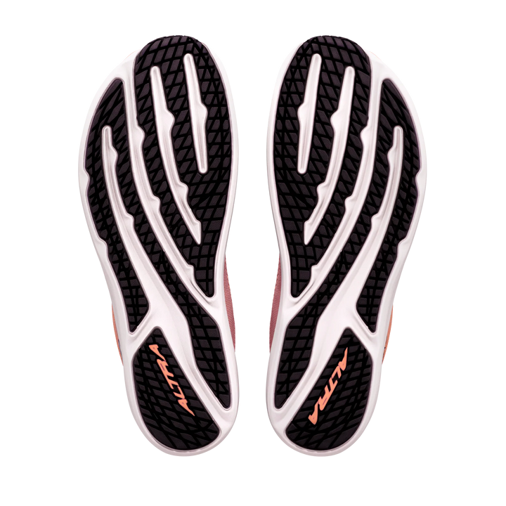 The image displays the black and white outsoles of the ALTRA Escalante 5 (Women’s) athletic shoes, each featuring “ALTRA” in orange text. The tread pattern combines curved and straight lines, emphasizing their performance-driven design. These shoes stand out with their Altra EGO midsole, offering responsive cushioning with every step.