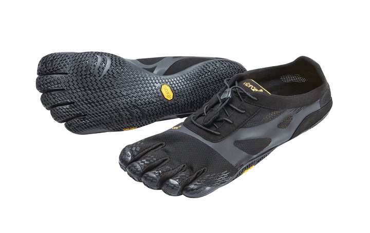 A pair of Vibram KSO Evo (Men's) black five-toe running shoes with textured soles, lace-up fronts, and yellow brand labels—ideal for fitness or plyometrics—shown with one flat and the other angled to display the sole.