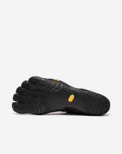 The Vibram KSO Evo (Men's) is a black minimalist shoe with individual toe compartments. Viewed from the bottom, it displays a textured rubber sole and yellow oval logo, closely mimicking the shape of a bare foot for ground feel and functional fitness.