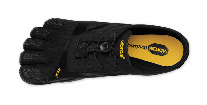 The Vibram KSO Evo (Men's) is a black FiveFingers shoe with individual toe pockets, black laces, and a yellow insole featuring the black Vibram logo. Ideal for balance workouts and functional fitness, shown here from an overhead view.
