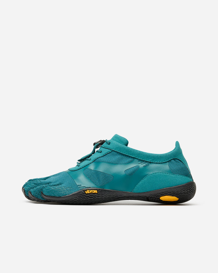 The Vibram KSO Evo (Women's) is a teal minimalist shoe with separate toe pockets, black sole, yellow accents, and mesh upper—ideal for balance workouts and functional fitness—shown in side profile on a white background.