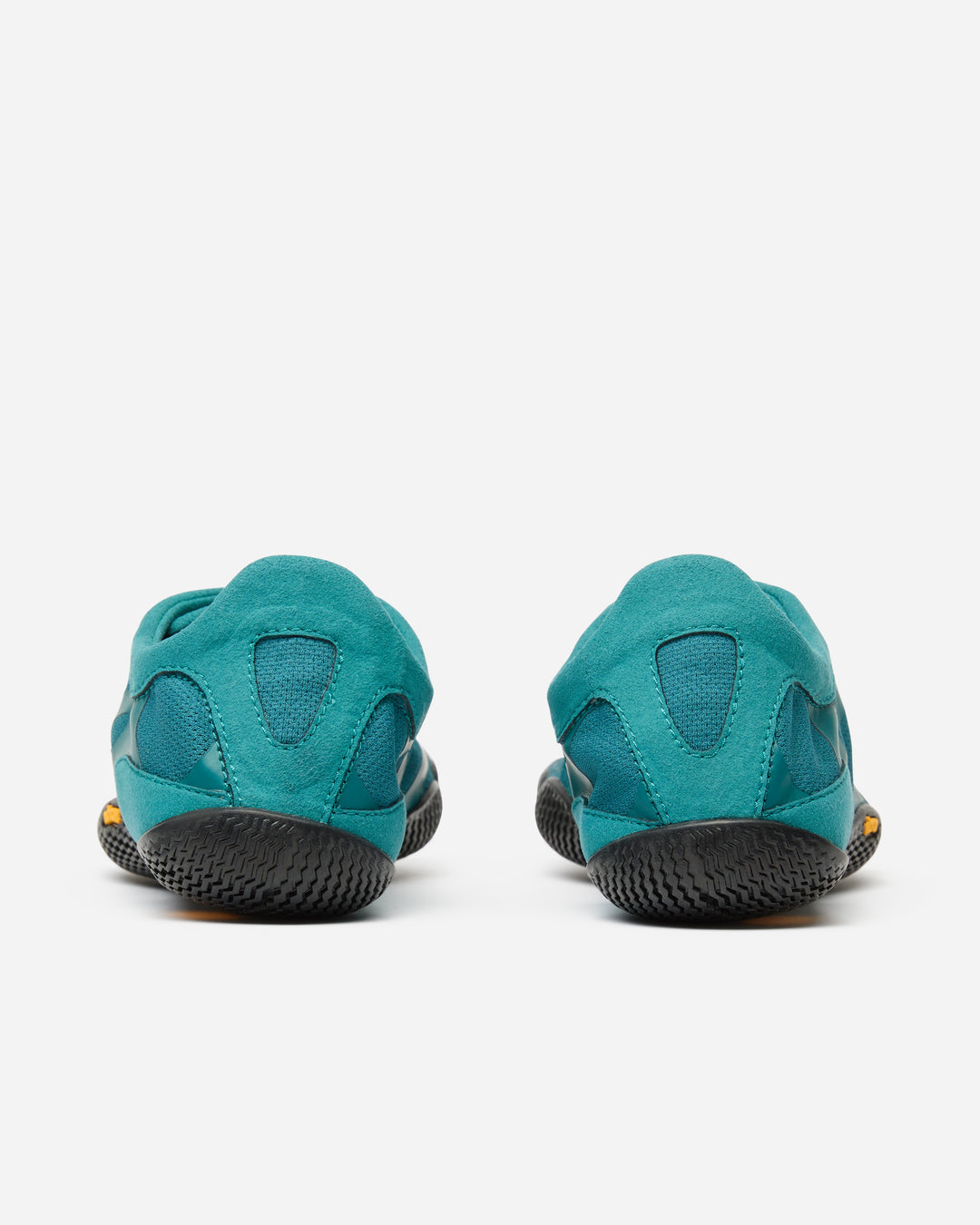 The Vibram KSO Evo (Women's) climbing shoes in teal are pictured from the back, highlighting their rounded heels, black textured rubber soles, and blue fabric uppers—ideal for balance workouts and functional fitness.
