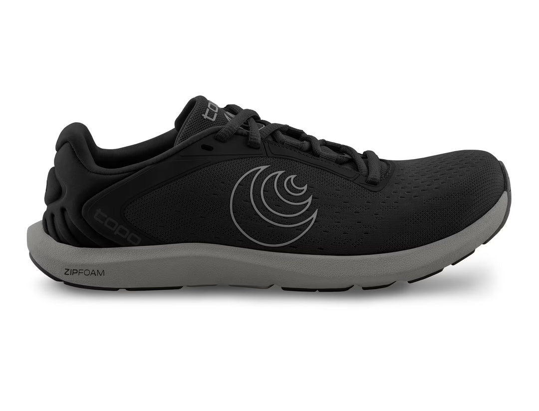 The TOPO ST-6 (Men's) is a black athletic running shoe with a gray sole, side logo, and lace-up closure. It offers a roomy toe box and lightweight ZIPFOAM cushioning for comfort and performance.