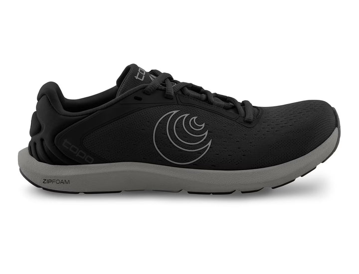 The TOPO ST-6 (Men's) is a black athletic running shoe with a gray sole, side logo, and lace-up closure. It offers a roomy toe box and lightweight ZIPFOAM cushioning for comfort and performance.