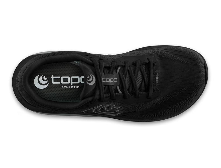 Top view of the TOPO Magnifly 6 (Men's) running shoe in black featuring black laces, visible TOPO logo on the insole, a breathable mesh upper, and a responsive ZipFoam midsole for comfort.