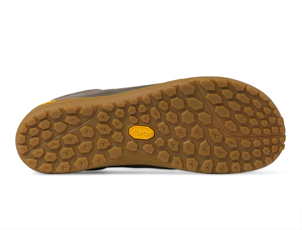 The image shows the bottom of a brown minimalist shoe sole from the TOPO Connect (Men’s), featuring a hexagonal tread pattern and a yellow Vibram logo in the center.